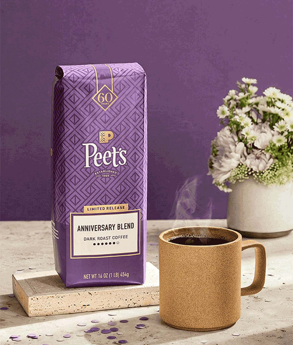 Peet's coffee package with a mug of coffee on a table against a purple background